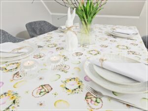 Zbliżenie na wykończenie brzegu obrusu wielkanocnego w kształcie fali oraz pastelowy nadruk pisanek.