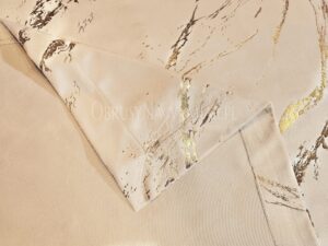 Eleganckie wykończenie brzegów beżowej narzuty velvetowej szytej na wymiar